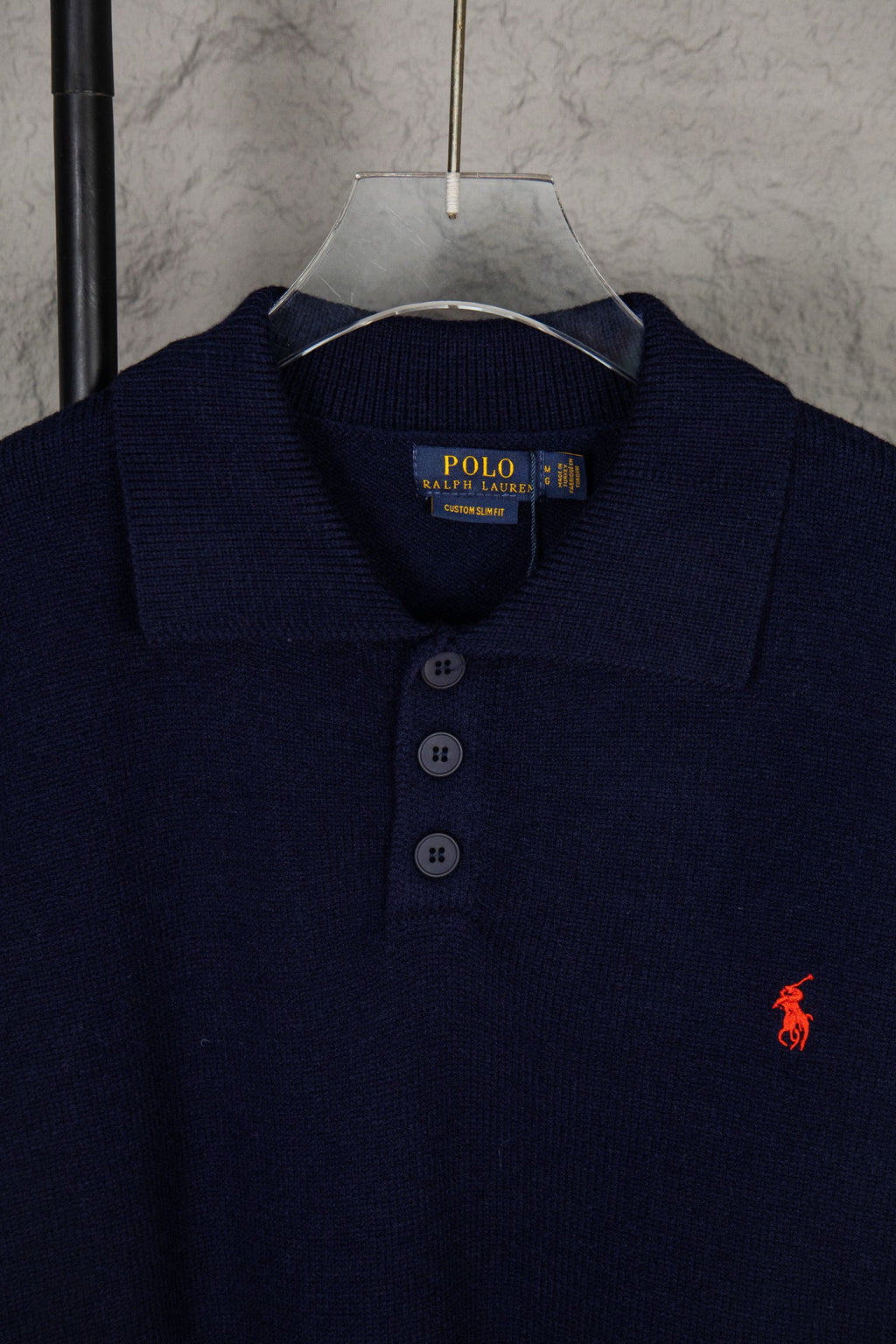 Navy knit polo sweater collar with three-button placket and Polo Ralph Lauren label