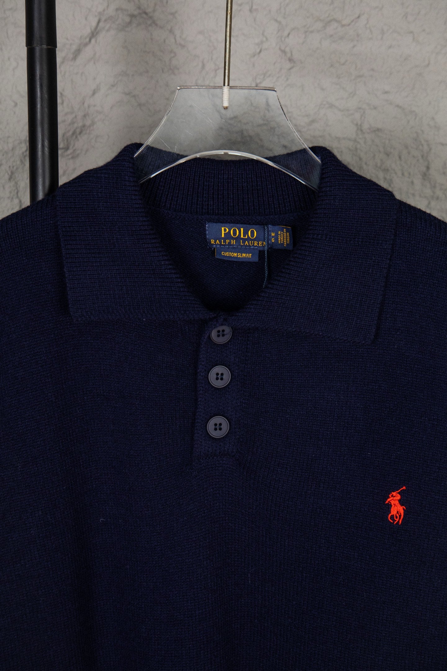 Navy knit polo sweater collar with three-button placket and Polo Ralph Lauren label