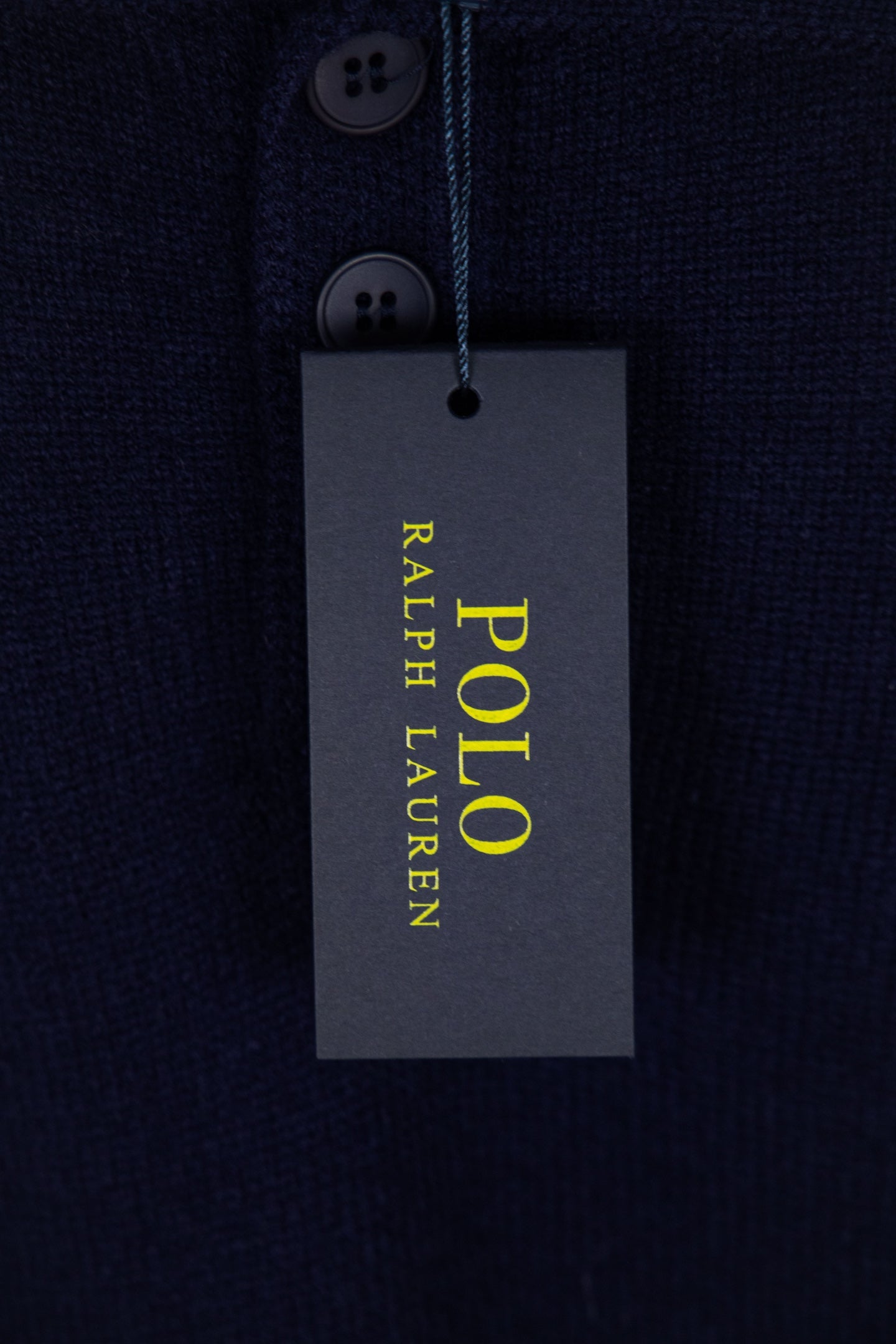 Navy knit polo sweater with hanging Polo Ralph Lauren care and sizing tag