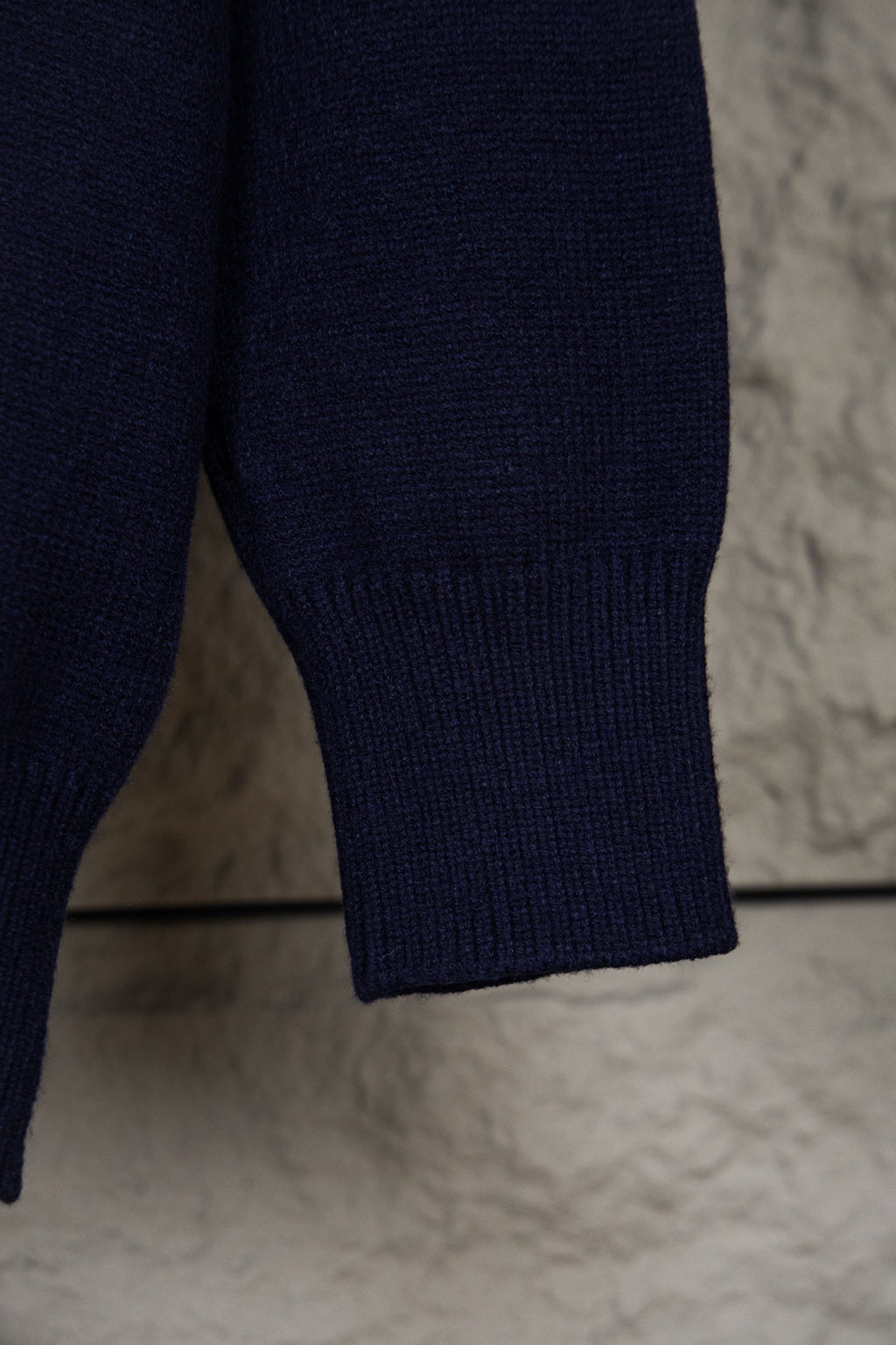 Navy knit polo sweater sleeve cuff with ribbed hem detail