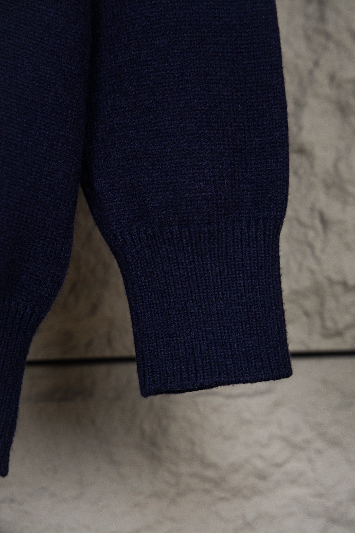 Navy knit polo sweater sleeve cuff with ribbed hem detail