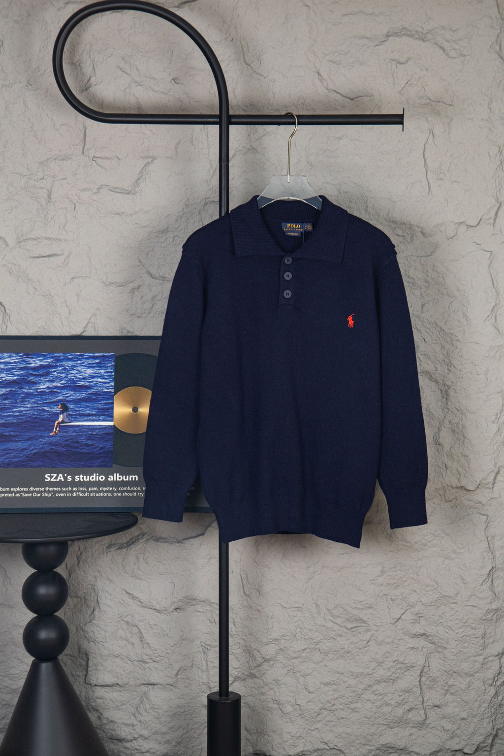 Navy knit polo sweater with button placket and red embroidered logo on chest