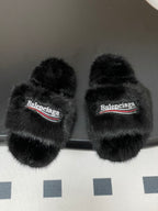 Black fuzzy slide sandals with two crossover straps and Balenciaga logo band
