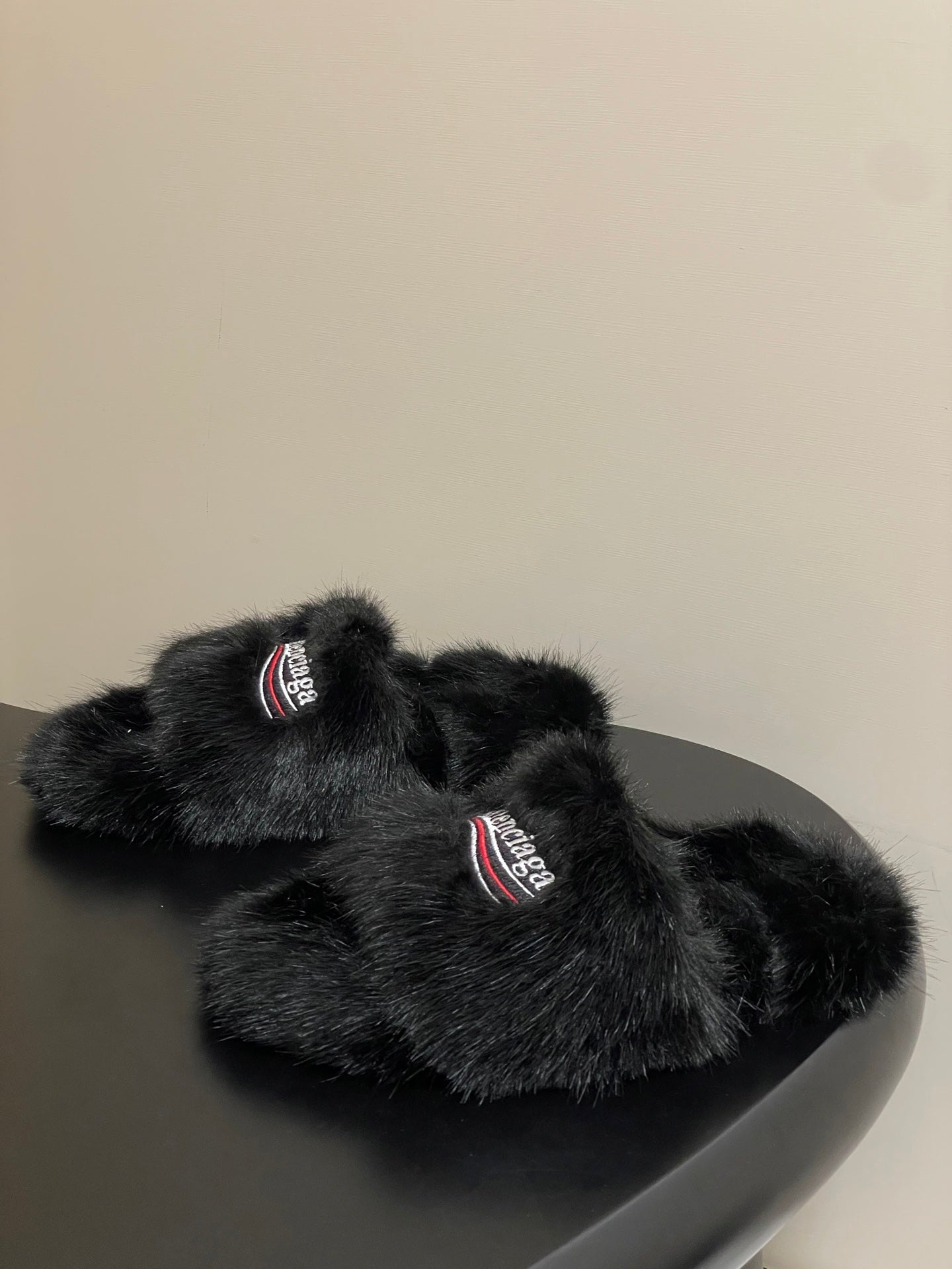 Black faux-fur slide sandals with Balenciaga logo patch on top strap