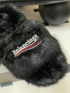 Black faux-fur slide sandal close-up, Balenciaga logo stripe on top band