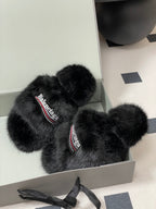 Black fuzzy slide sandals with Balenciaga logo straps, placed in open box