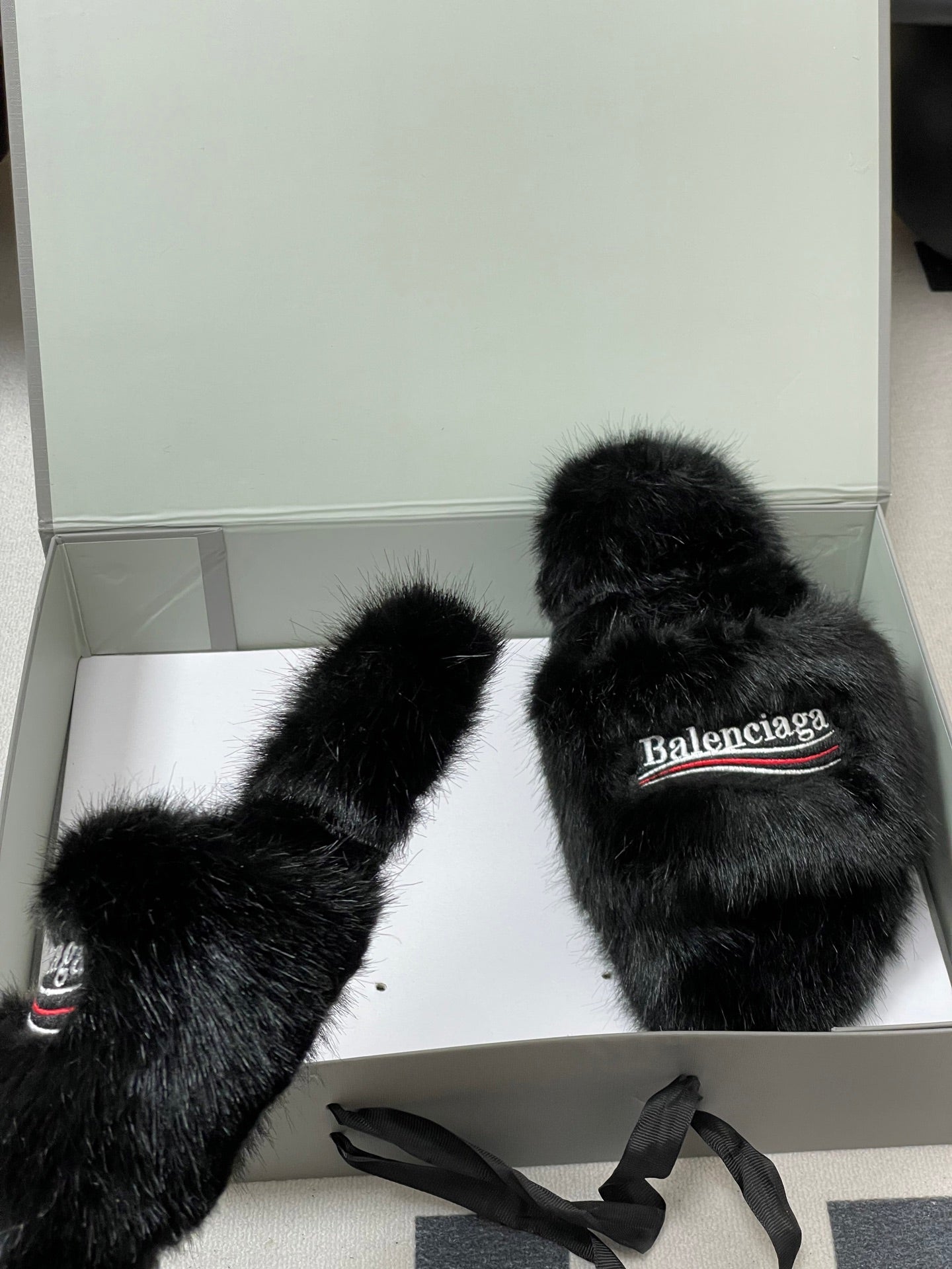 Black fuzzy slide sandals on box base, Balenciaga logo straps