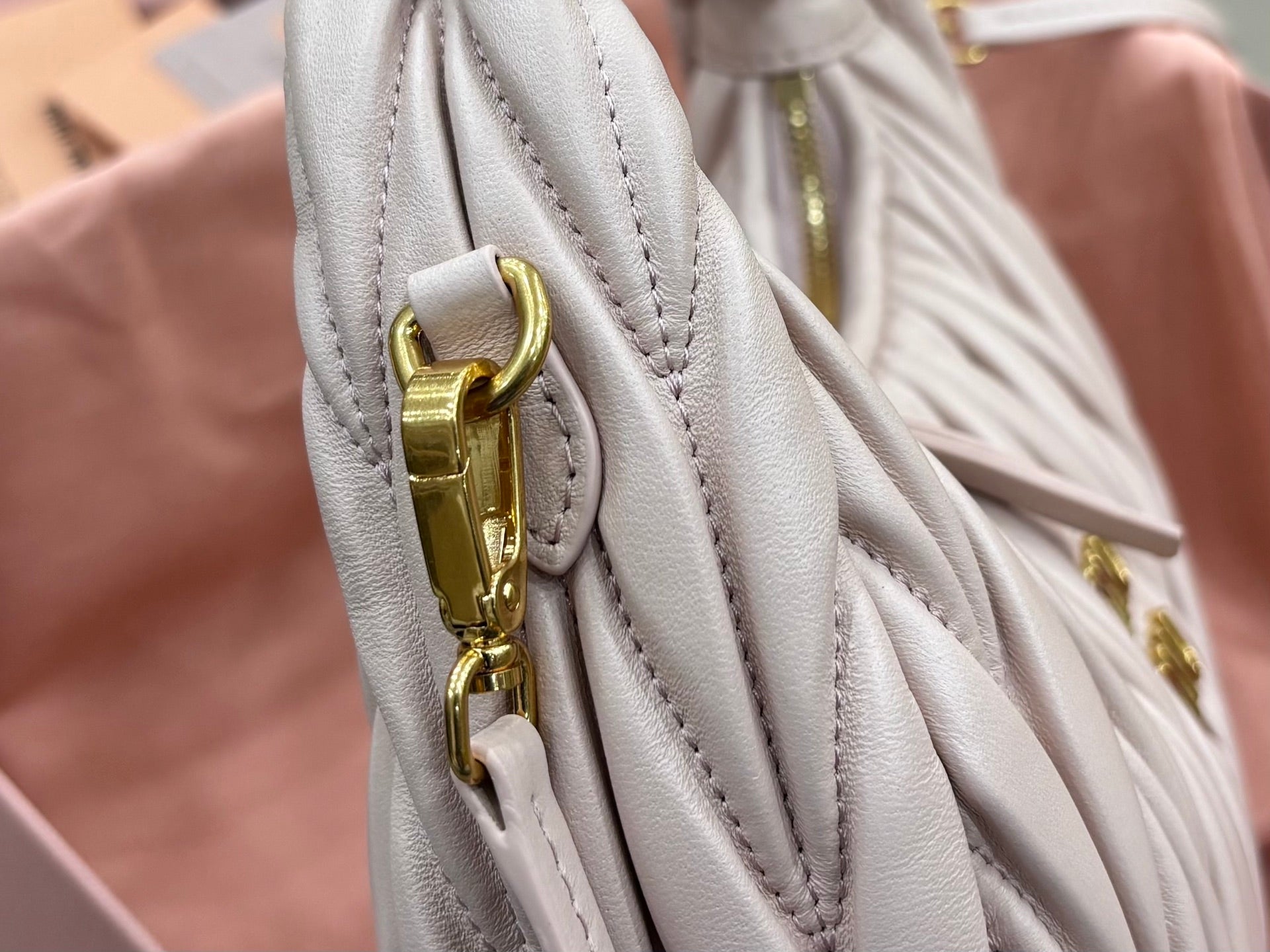 MiuMiu cream quilted bag detail with gold chain strap clasp and stitching
