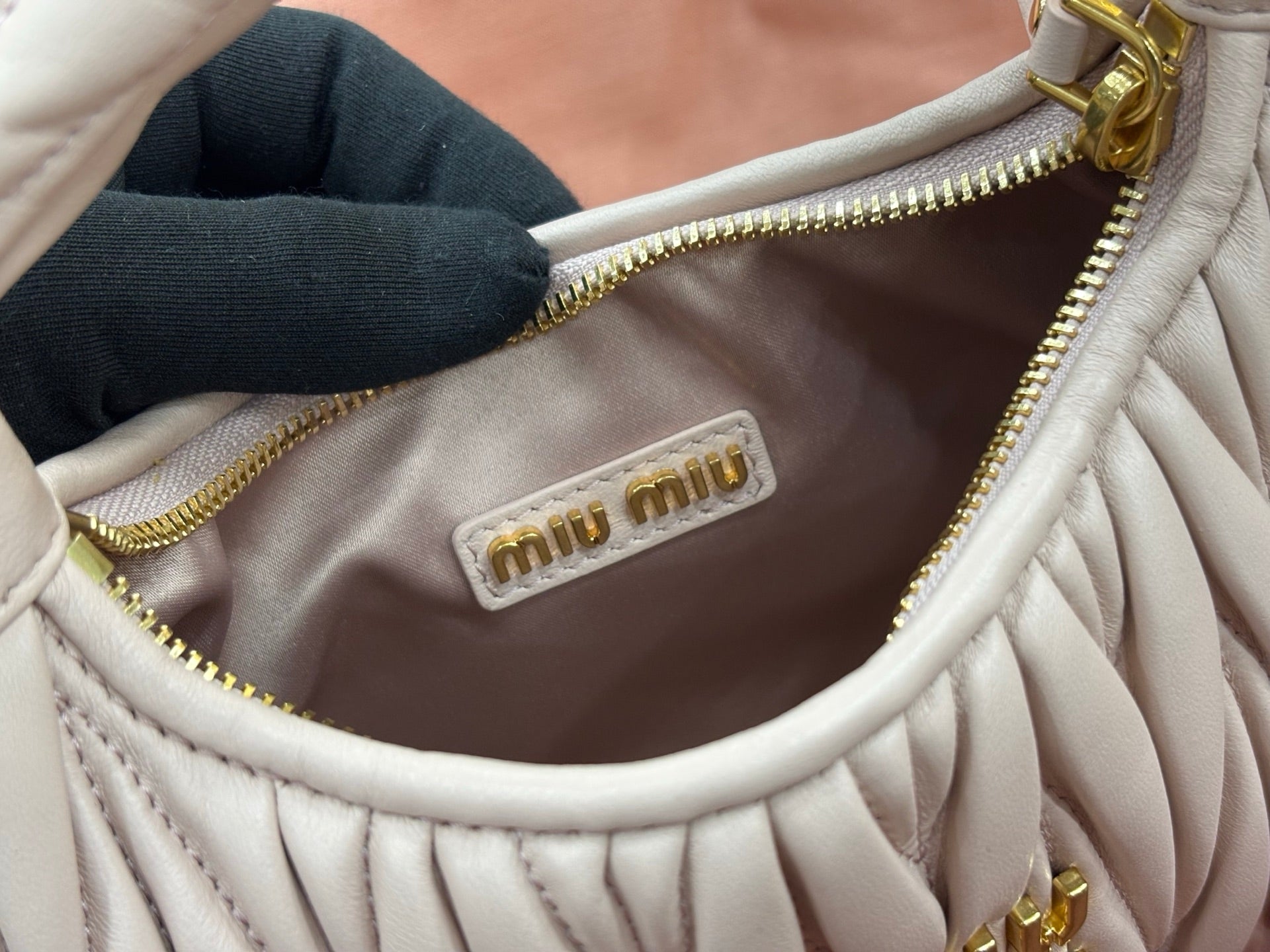 MiuMiu cream quilted bag interior with small logo patch near gold zipper