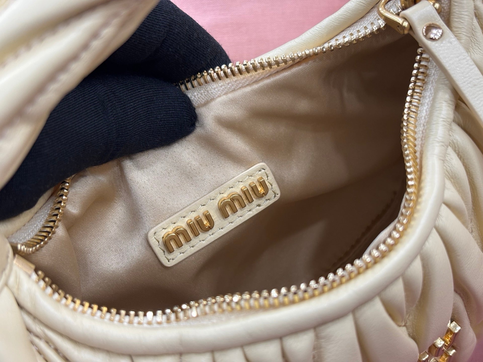 MiuMiu mini hobo bag interior with logo tag and zipper pocket in pale yellow leather