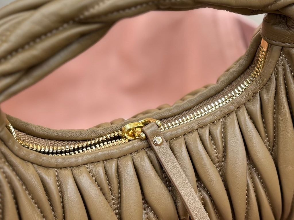 MiuMiu olive green hobo bag close-up of top edge trim and gold zipper pull