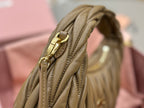 MiuMiu olive green mini bag close-up of side handle and gold-tone buckle hardware