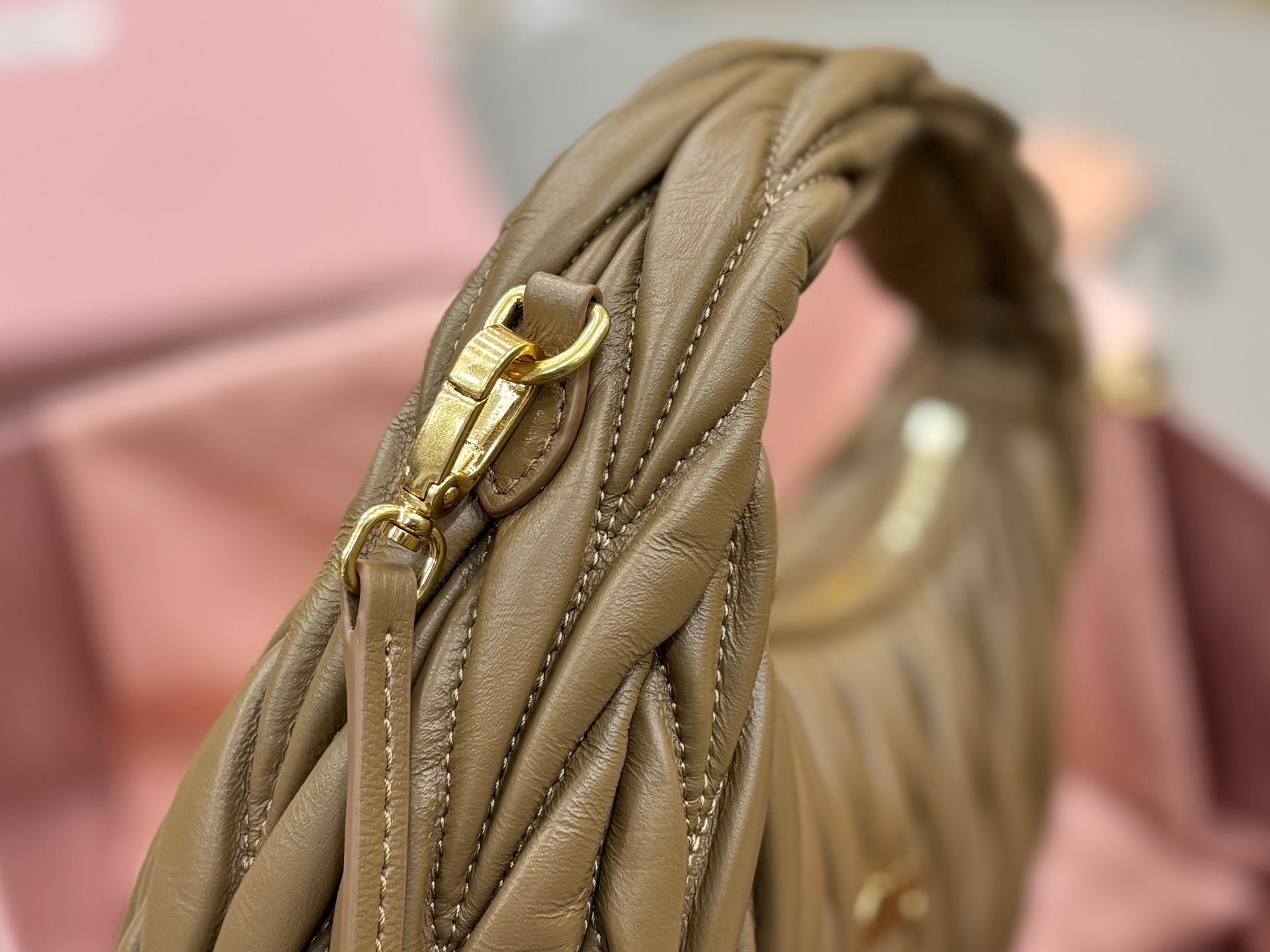 MiuMiu olive green mini bag close-up of side handle and gold-tone buckle hardware