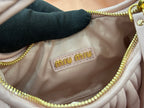 Lavender mini handbag interior with 'miu miu' logo patch, gold trim, and dark lining