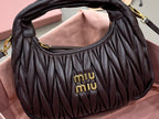 MiuMiu black ruched mini bag front with “miumiu” logo and arched top opening