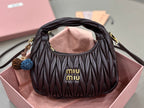 MiuMiu black quilted mini bag with gold-tone hardware and “miumiu” logo on front