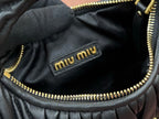 Black leather handbag interior with gold zipper trim and Miu Miu logo patch