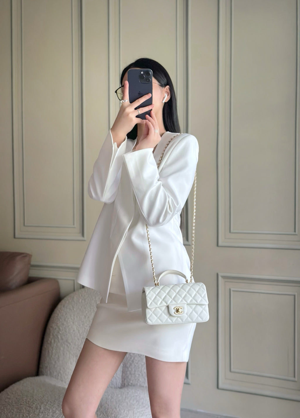 White quilted mini handbag worn crossbody with gold-tone chain strap