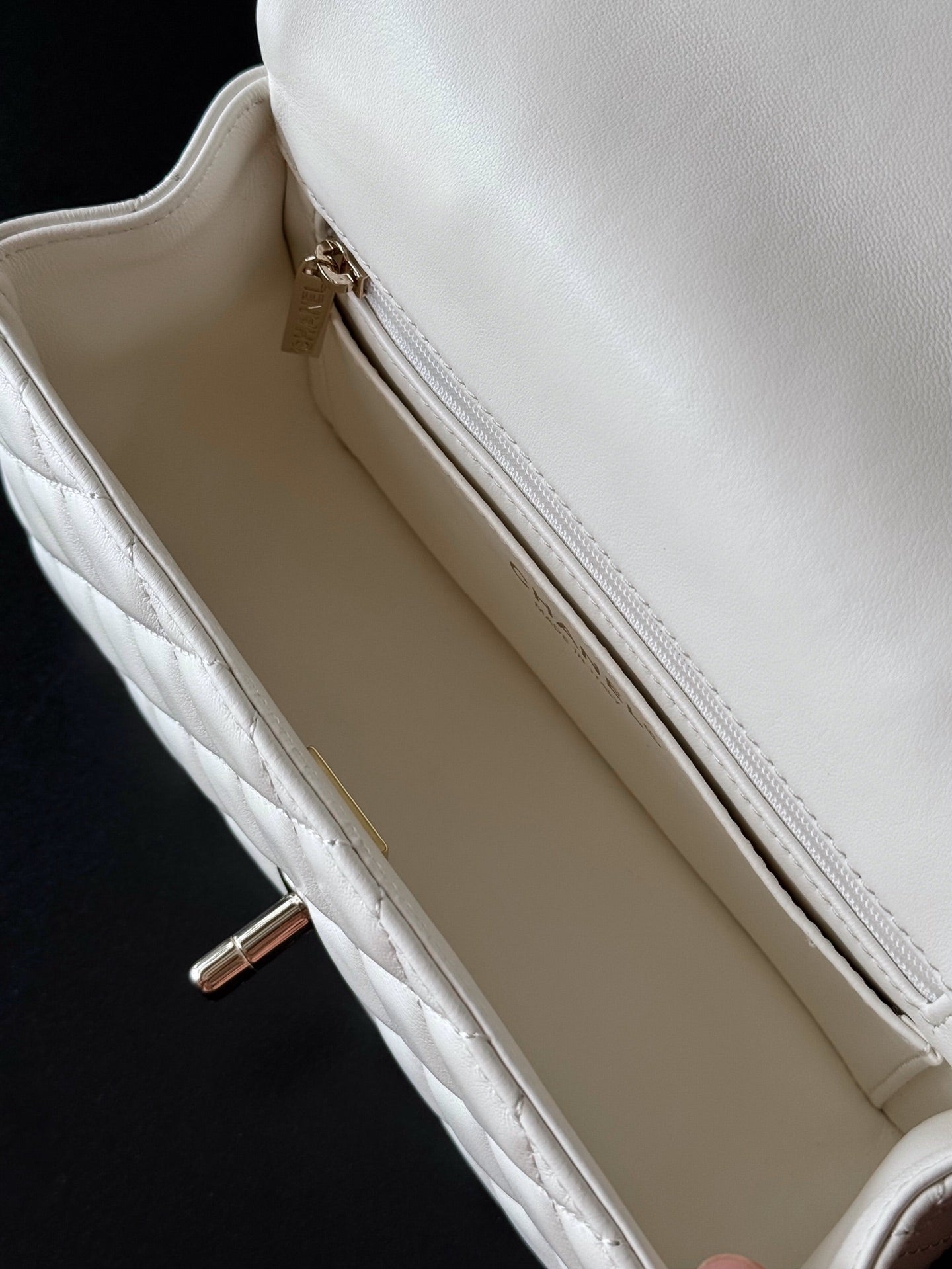 Chanel quilted white bag interior view with zipper and slip pocket