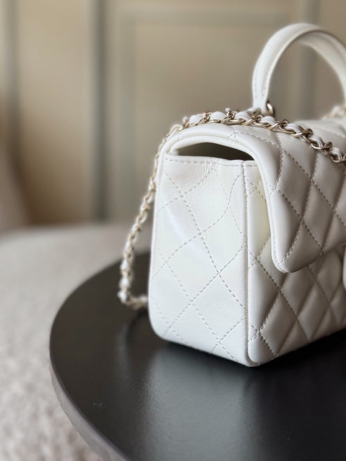 Chanel quilted white handbag, side view with chain strap and gold-tone clasp