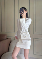 Chanel quilted white mini bag worn with chain strap and flap closure