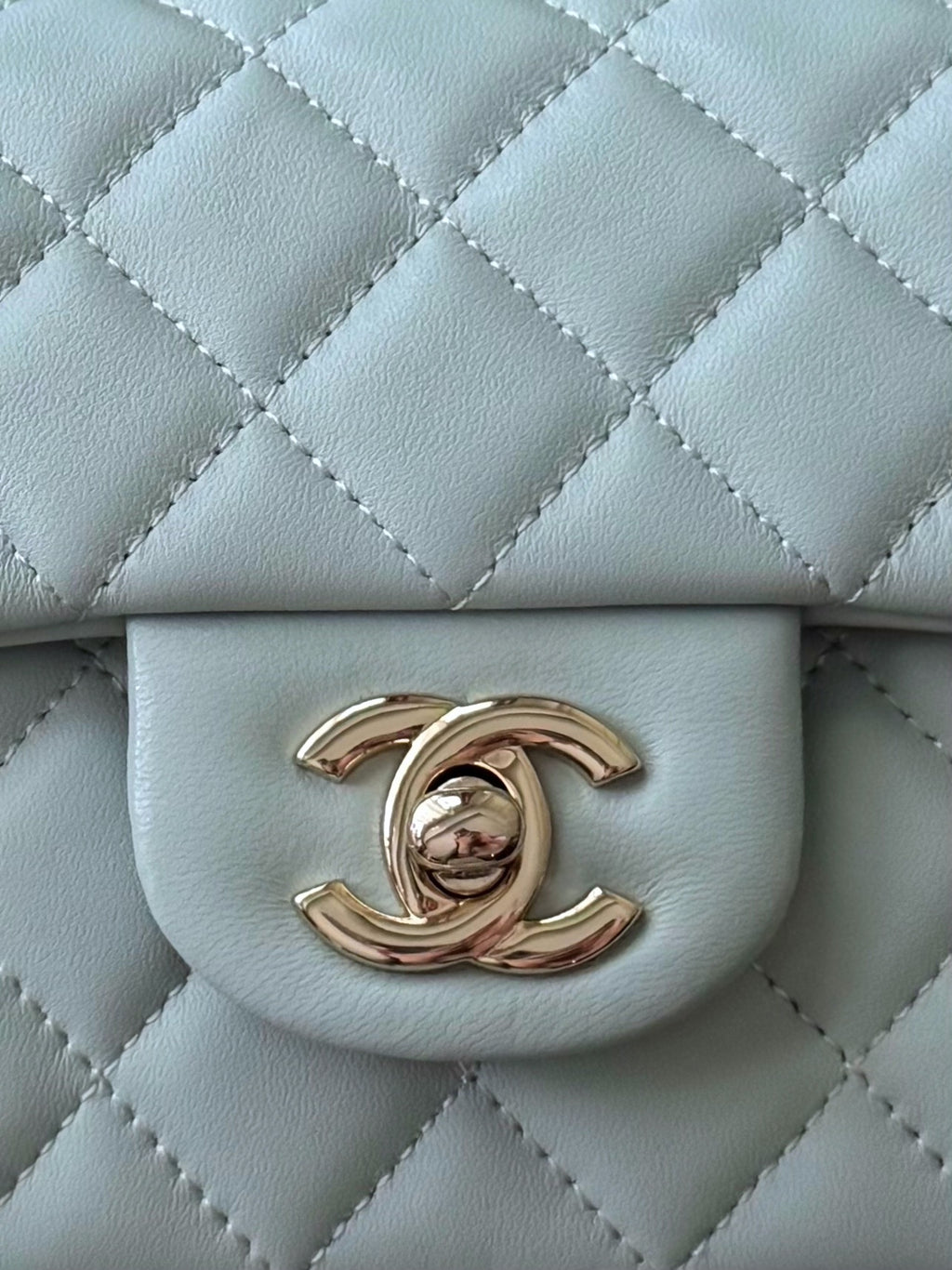 Chanel bag flap in light blue with quilted texture and gold-tone logo clasp