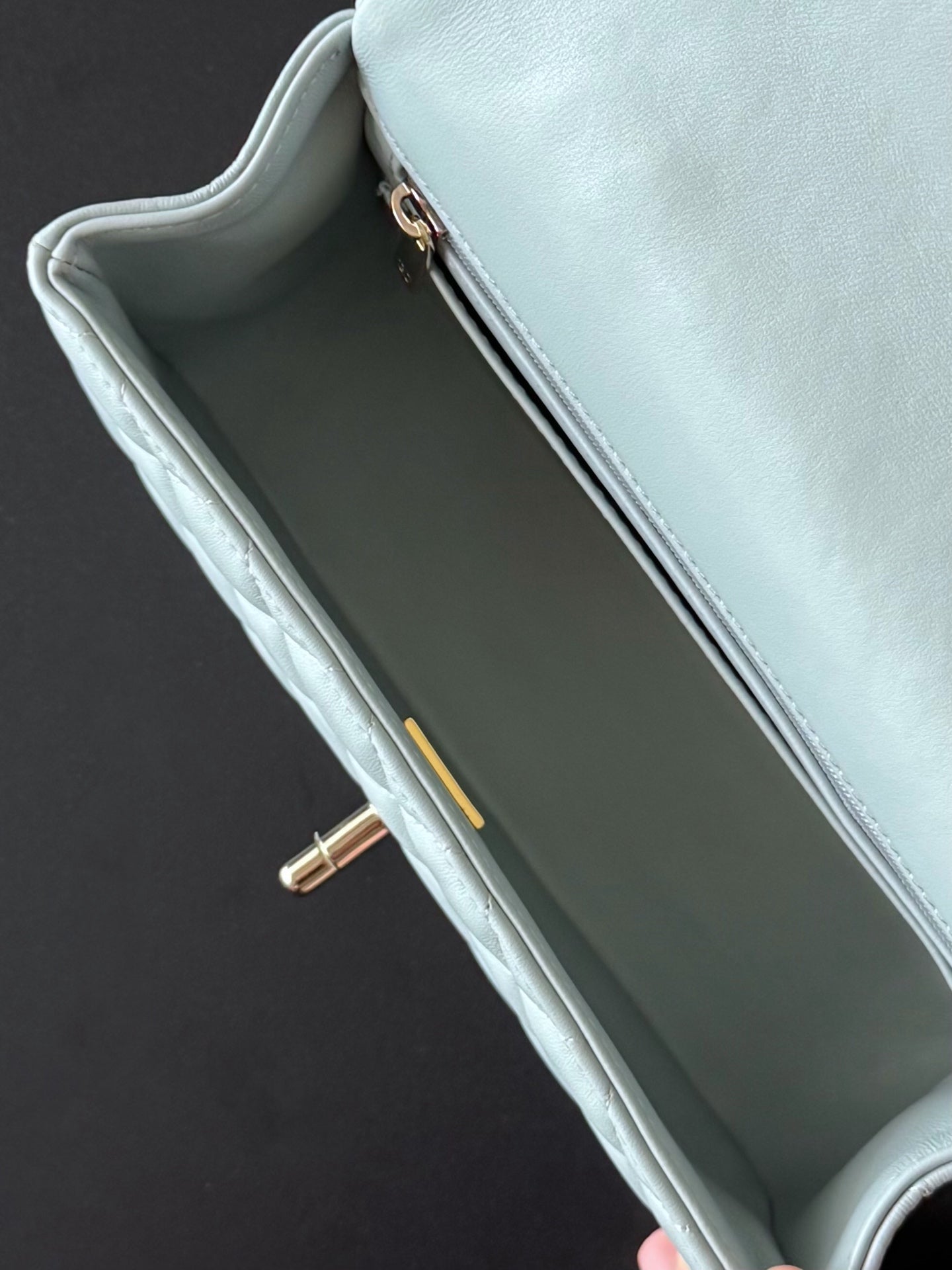 Chanel bag in light blue with open top and gold-tone zipper on the inner edge