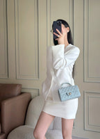 Chanel bag in light blue quilted mini on chain strap, worn crossbody with flap logo