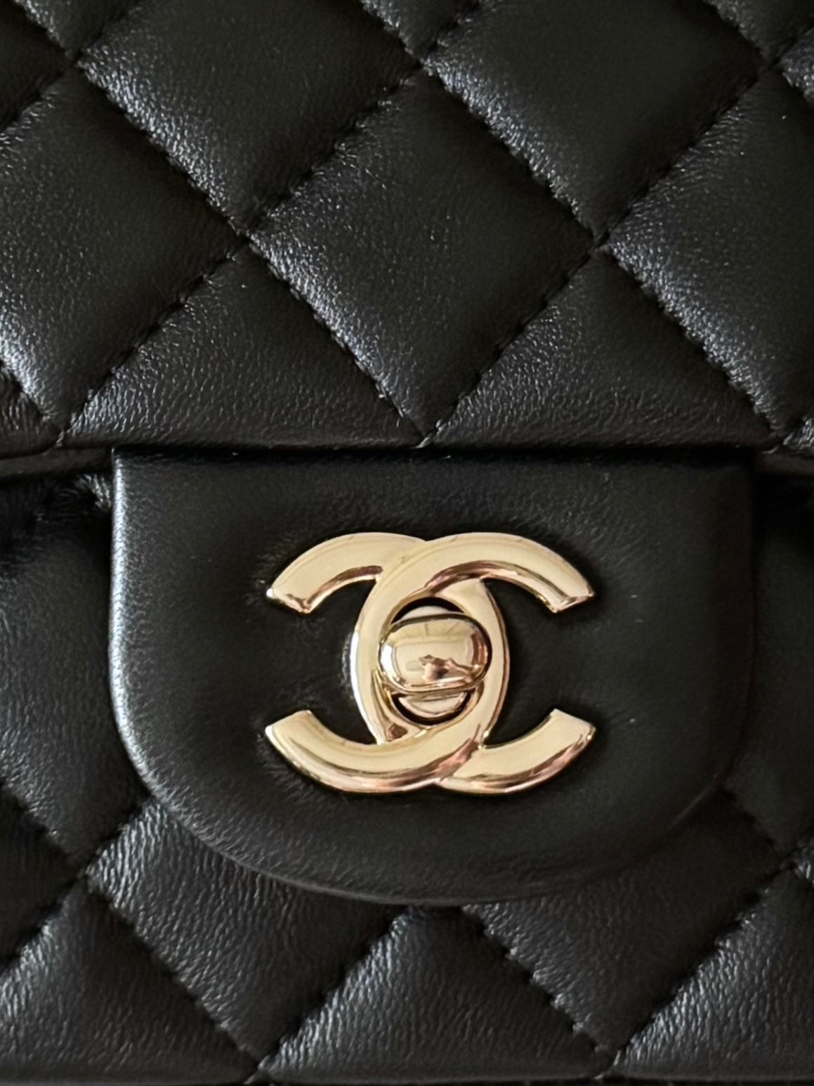 Quilted dark handbag with Chanel CC gold logo on front flap