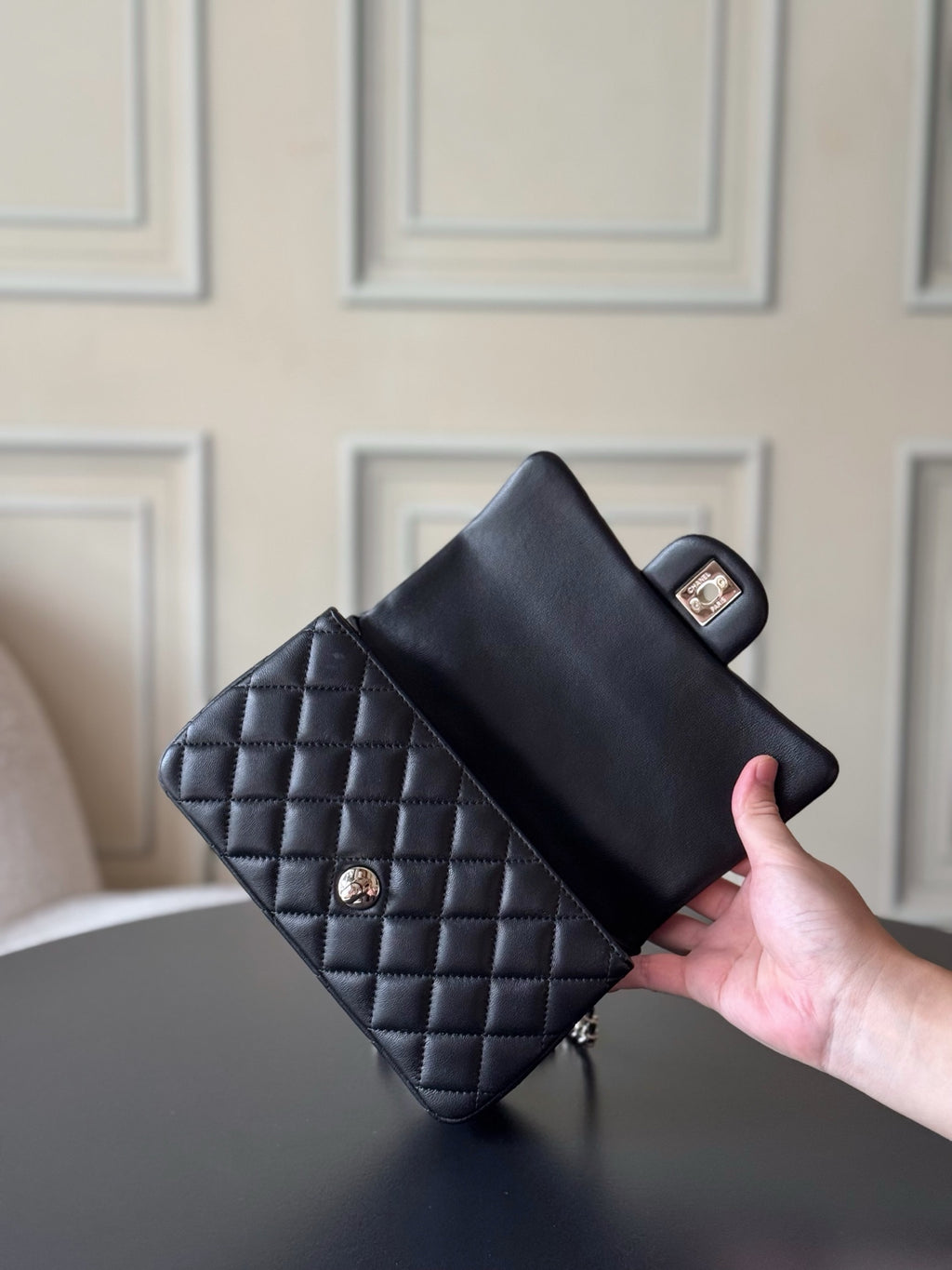 Quilted dark handbag with flap closure, top handle, gold logo plaque