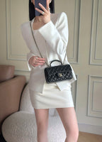 Quilted handbag with chain strap and top handle, dark navy, worn on shoulder