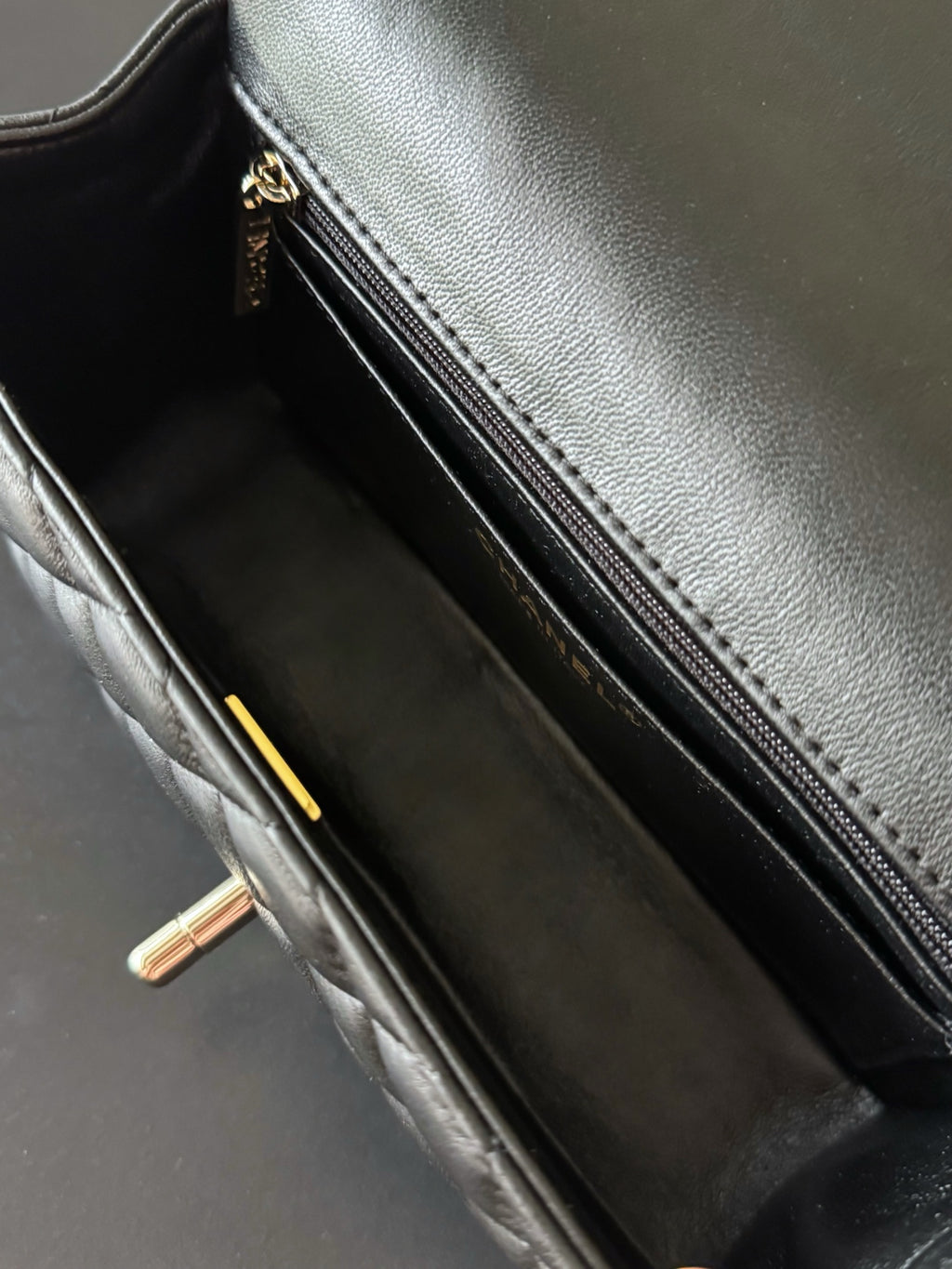 Quilted handbag interior with zip pocket and gold zipper pull, dark lining