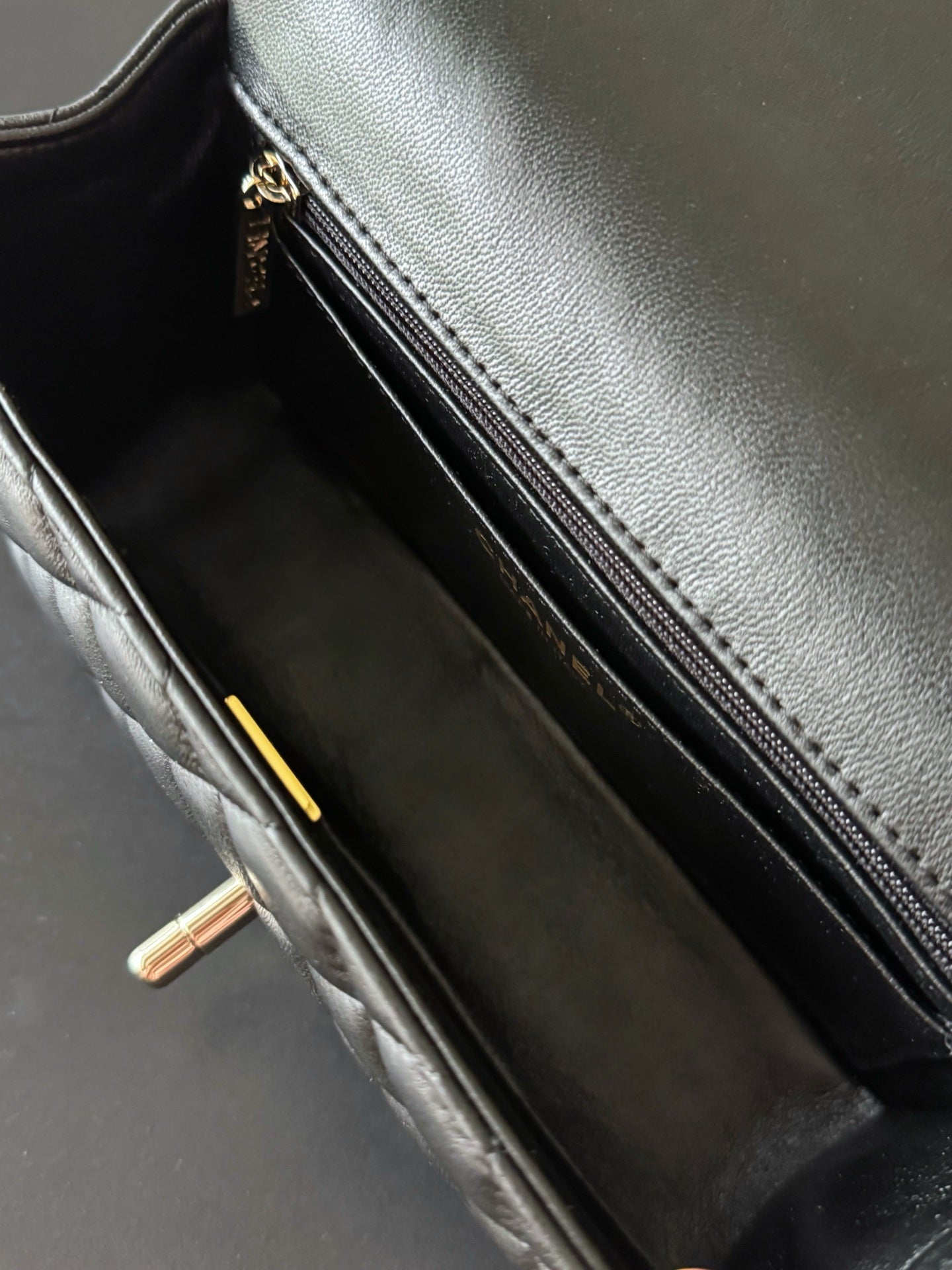 Quilted handbag interior with zip pocket and gold zipper pull, dark lining