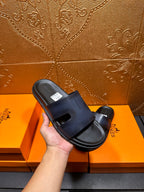 Hermes dark blue slide sandal held in hand, open toe and wide strap