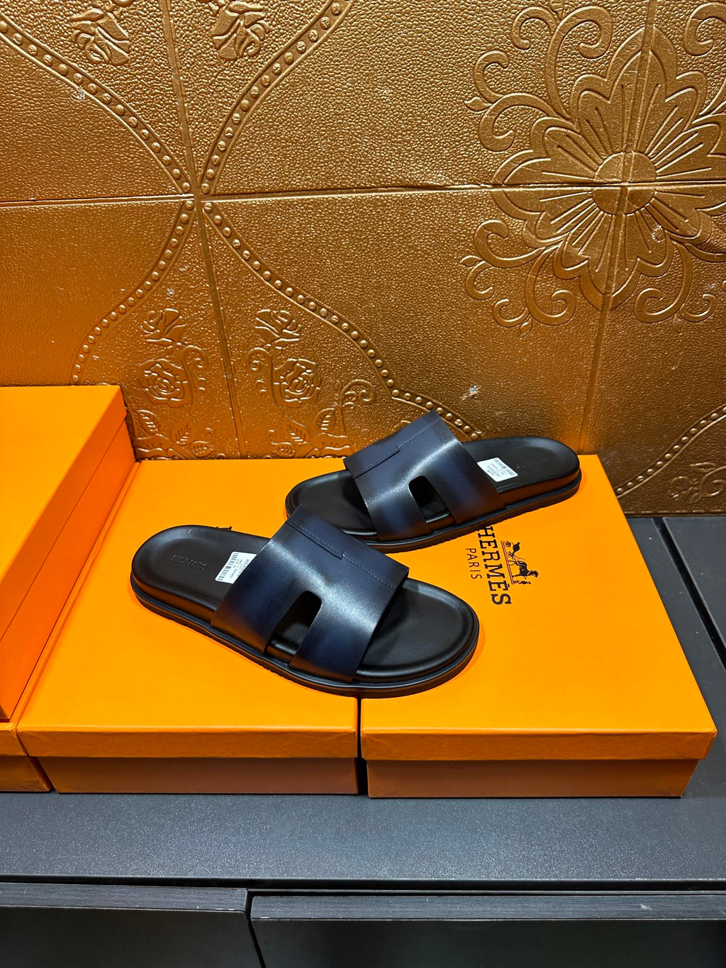 Hermes dark blue leather slide sandals, angled view with wide strap detail