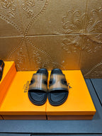 Hermes slide sandals with dark sole and gray-tan wide strap, open toe