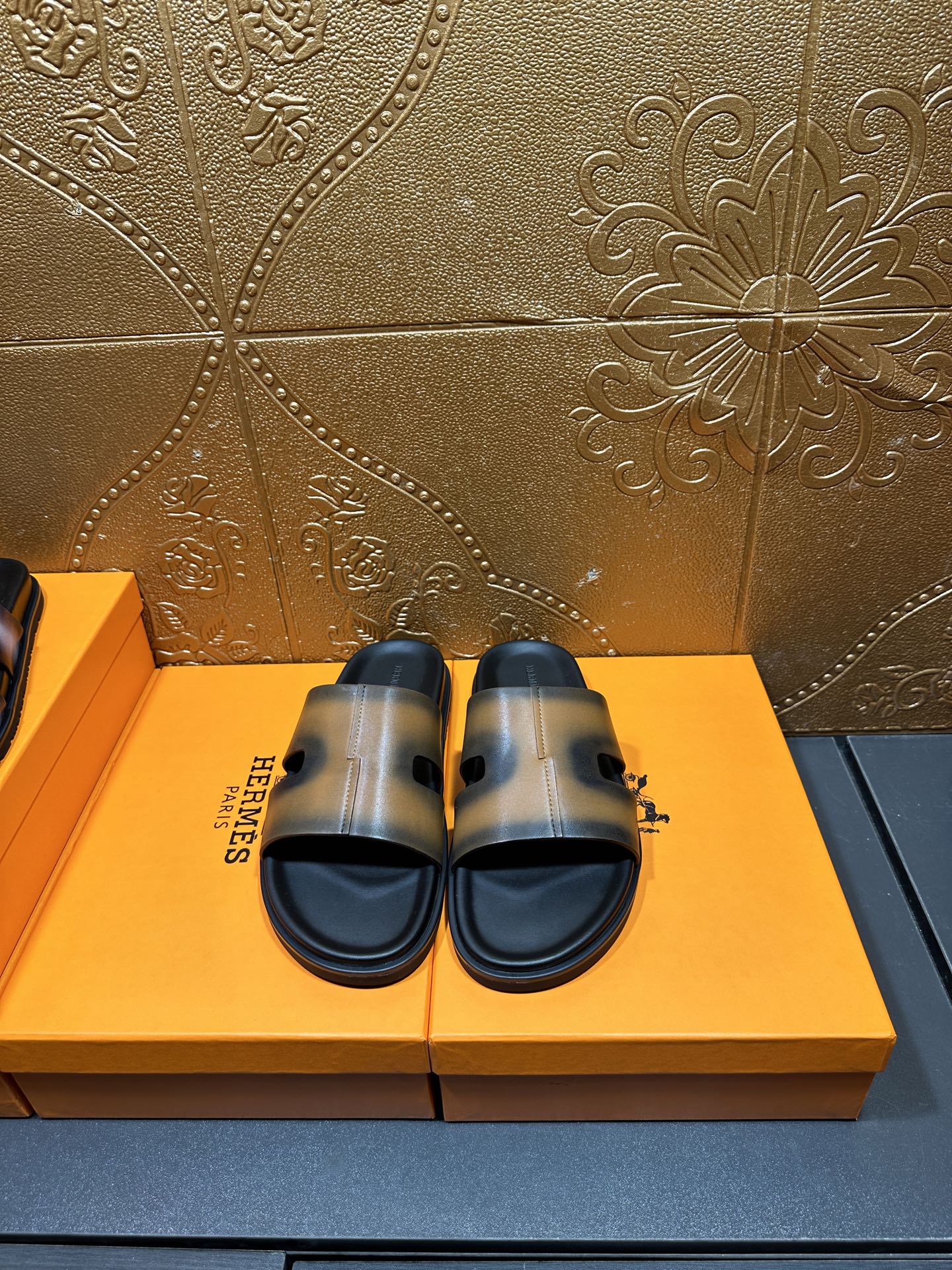 Hermes slide sandals with dark sole and gray-tan wide strap, open toe