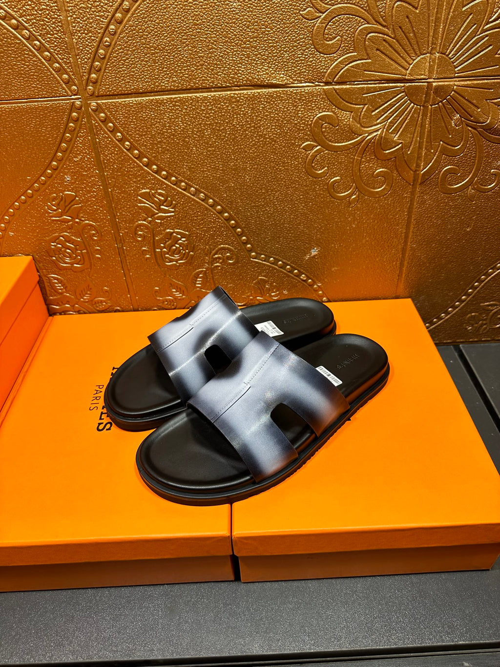 Hermes slide sandals with metallic blue upper and black outsole, angled view