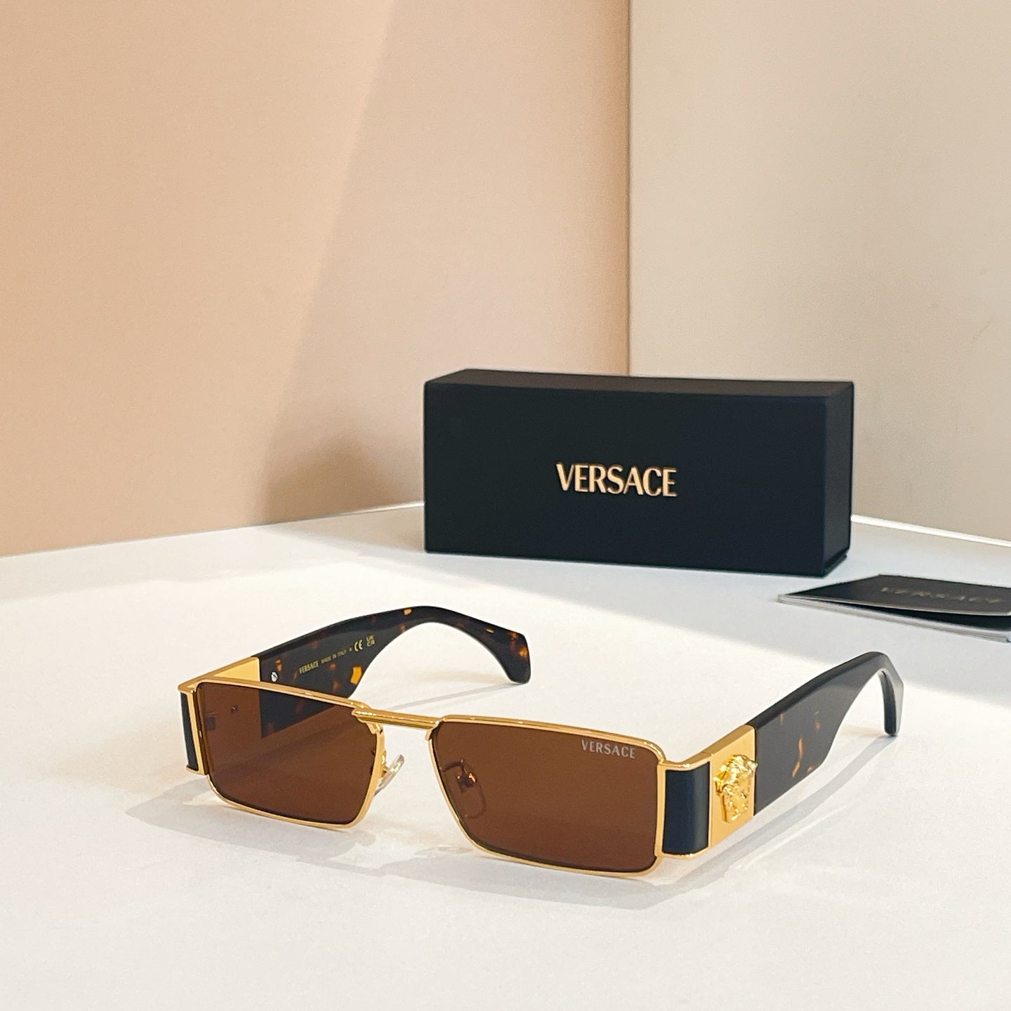 Versace rectangular sunglasses with brown lenses and gold frames, patterned dark temples
