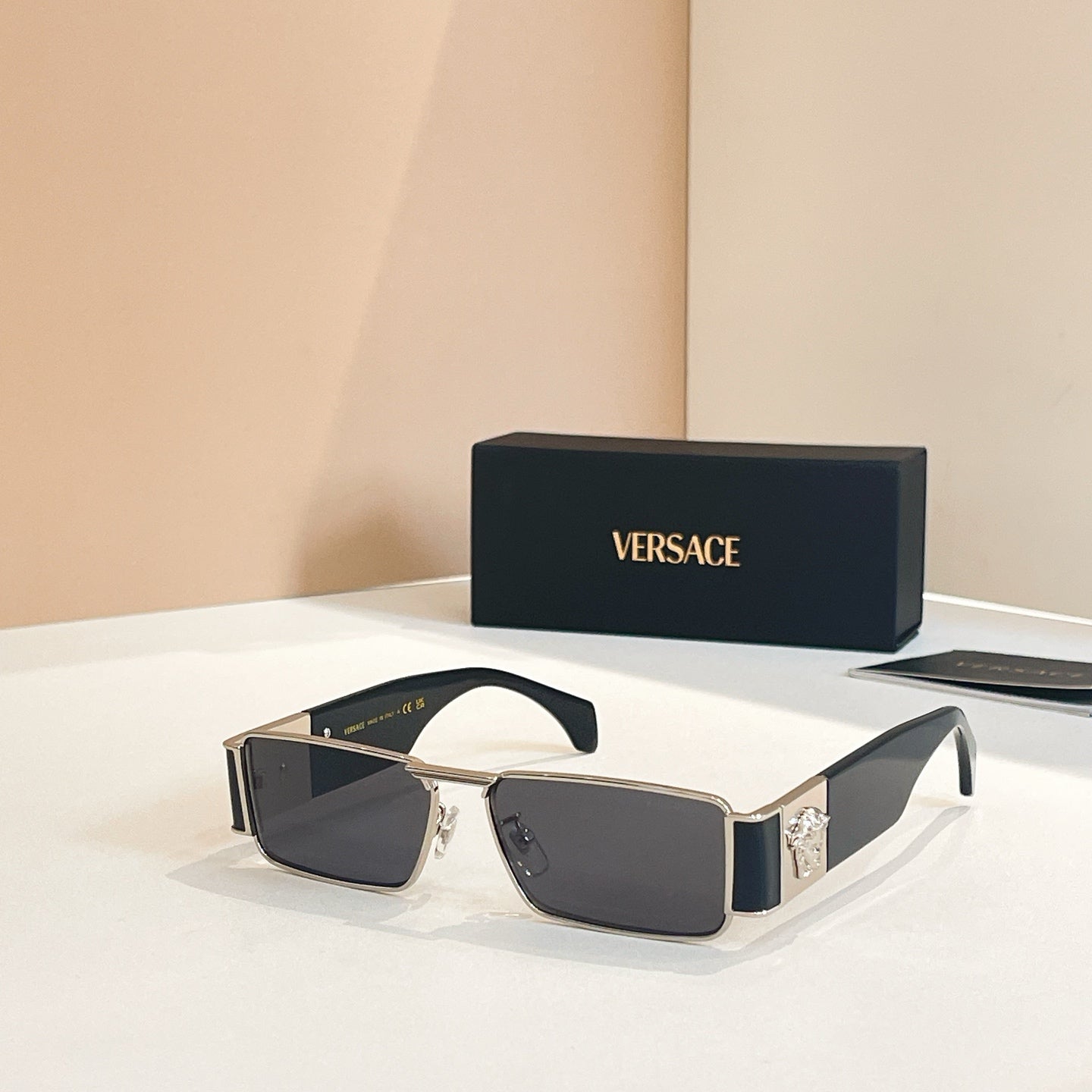 Versace rectangular sunglasses with dark lenses and gold frames, black temple accents