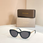 Bvlgari sunglasses with dark blue frames and dark oval lenses, gold-tone temple detail