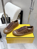 Brown low-top sneakers with lace-up front, textured trim and rubber cup sole