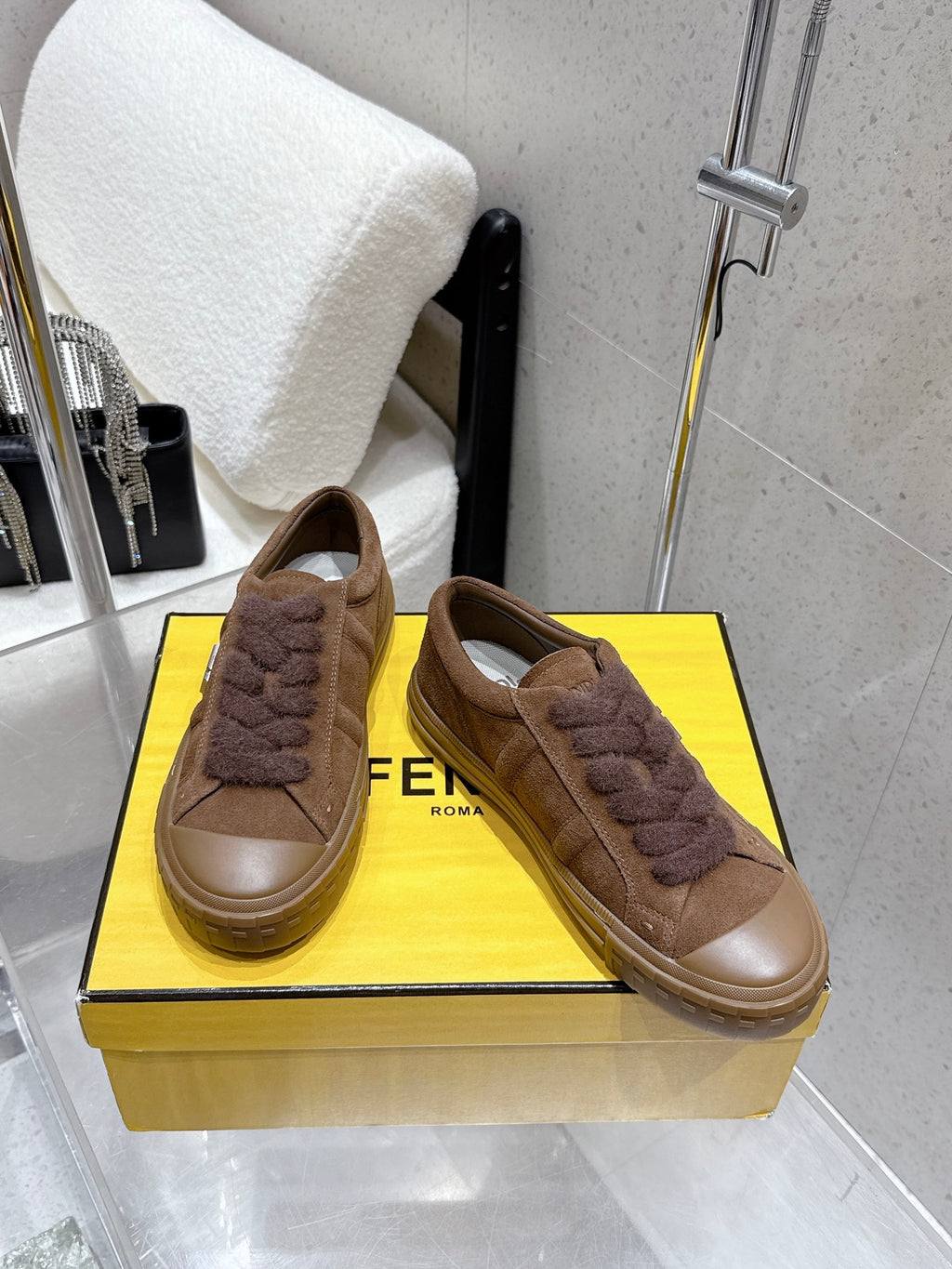 Pair of brown low-top sneakers with fuzzy laces and Fendi logo patch