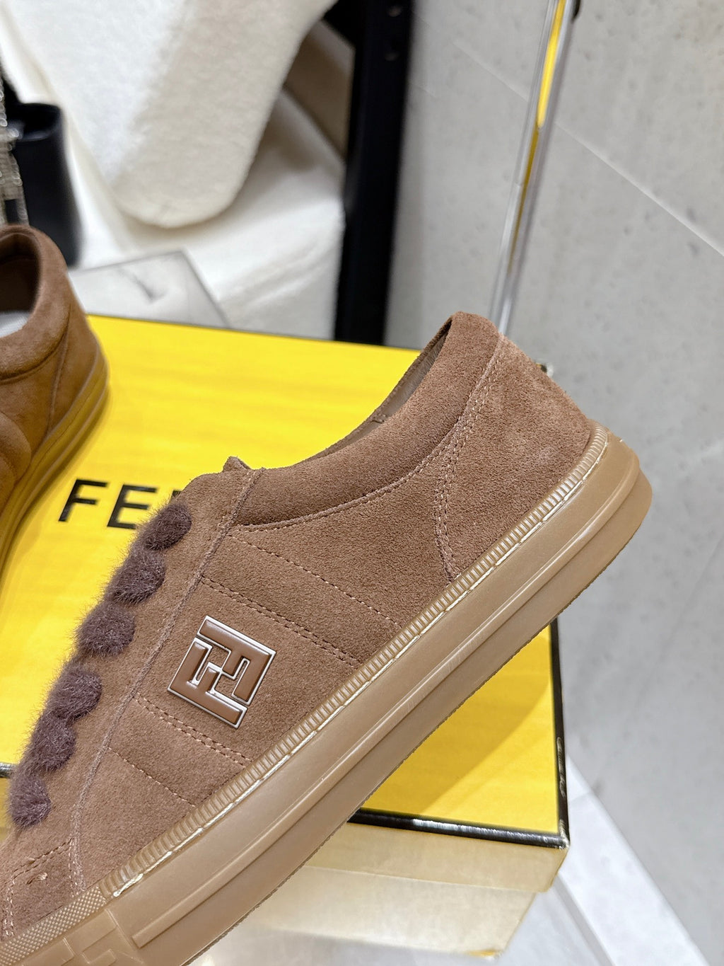 Brown suede sneaker with square side logo plate, fuzzy laces and contrast stitching