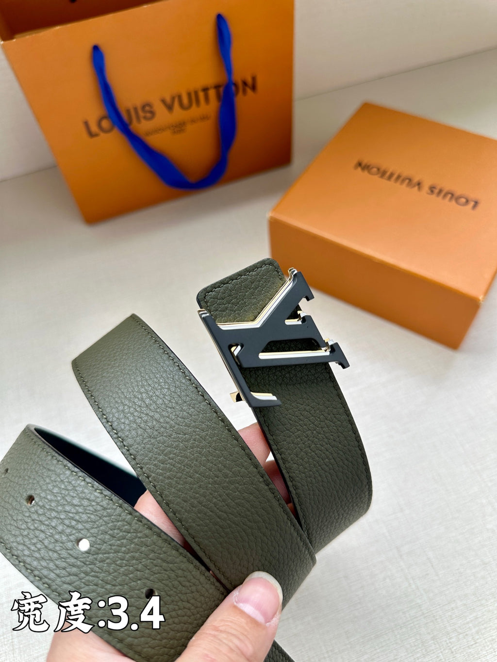 Dark green leather belt with silver buckle, visible stitching and punched holes