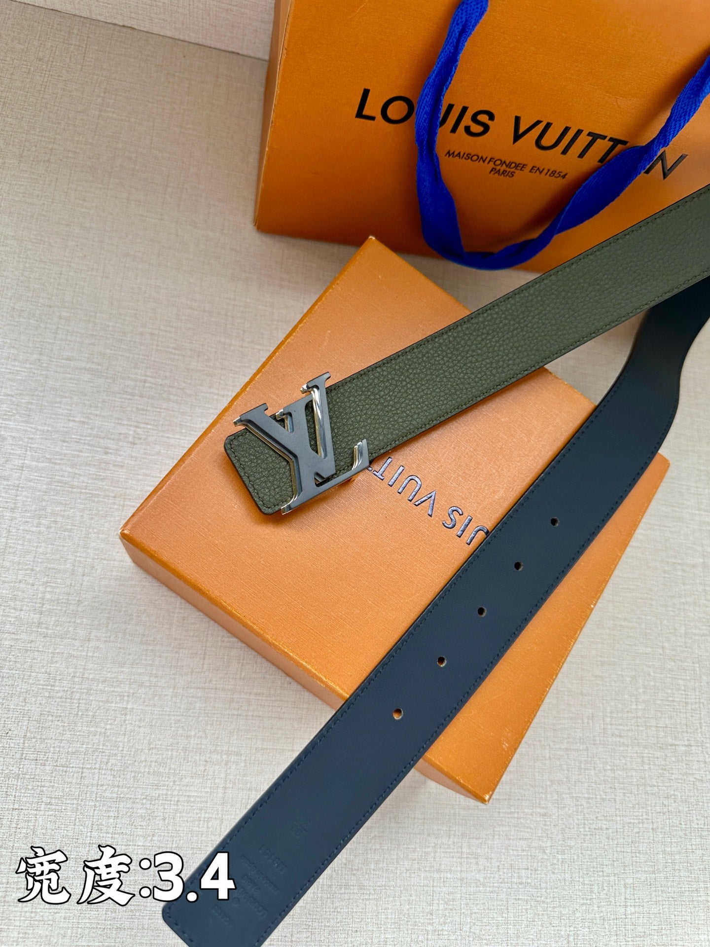 Dark green leather belt with silver buckle detail and punched holes