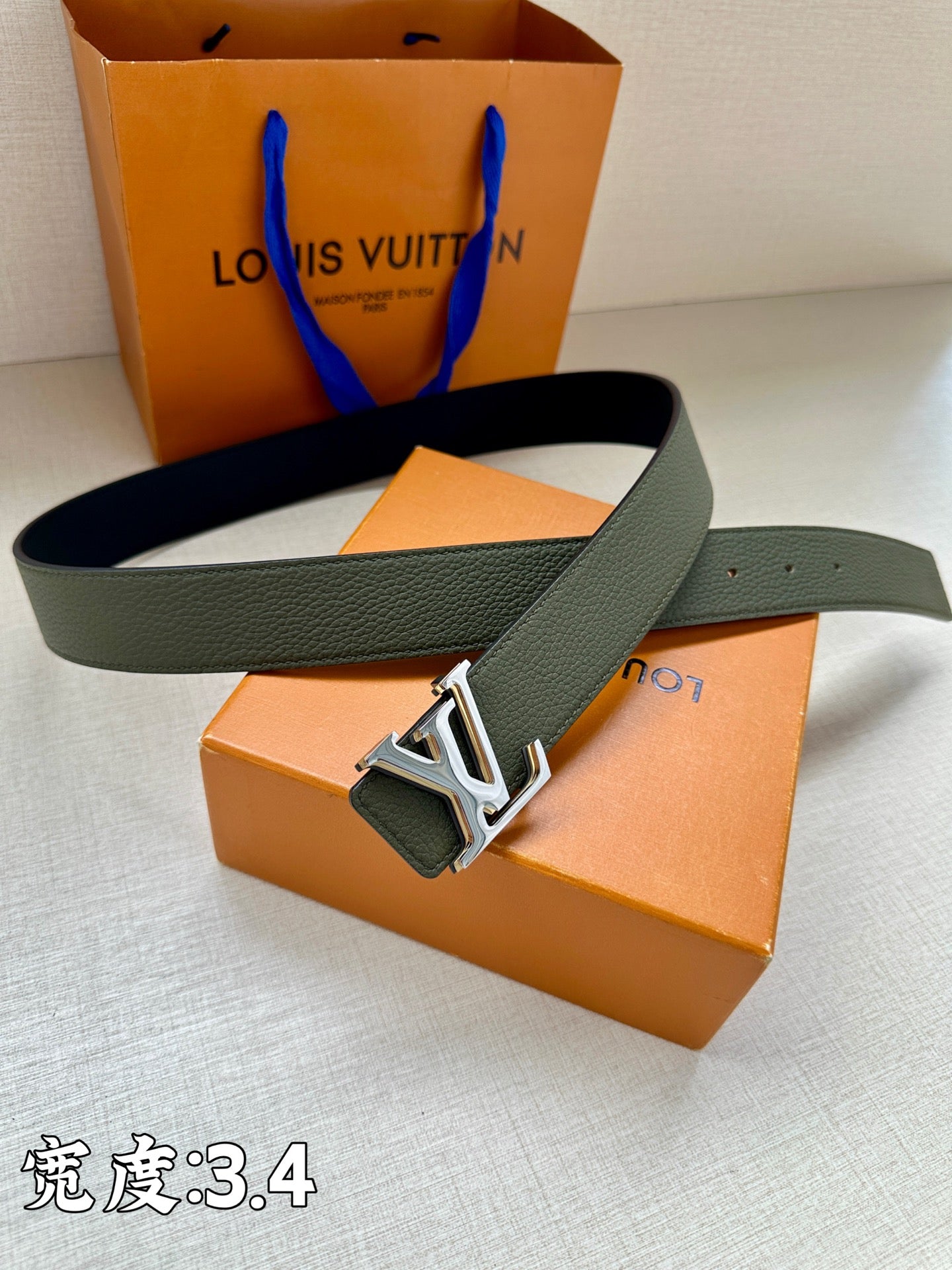Dark green leather belt with silver LV buckle centerpiece and eyelet holes