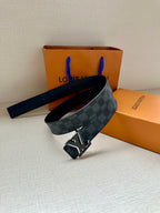 Monogram belt with dark blue check strap and gold-tone buckle, strap across surface