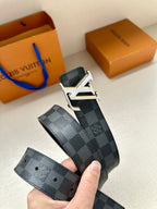 Monogram belt held in hand, dark blue check strap with gold-tone buckle and holes