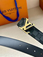 Monogram belt strap detail with dark blue check pattern, gold-tone buckle, punched holes